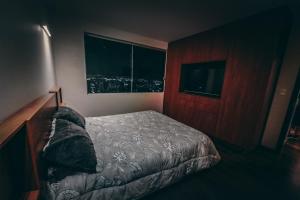 a small bedroom with a bed and a window at Departamento con piscina y vistas hermosas in Cochabamba