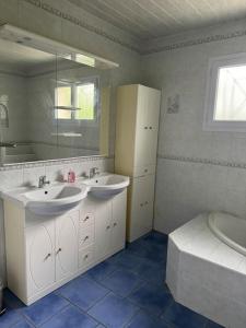 bagno con 2 lavandini e servizi igienici di Jolie maison avec jardin proche bordeaux et océan a La Brede