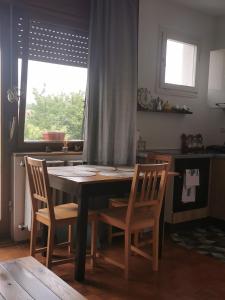 a table and chairs in a kitchen with a window at Apartman Aurora in Slavonski Brod