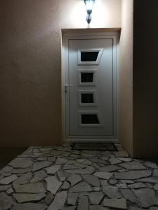 eine Tür in einem Zimmer mit Steinboden in der Unterkunft In Apartments AirPort in Mitrovići