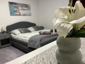 un jarrón con flores blancas sobre una mesa en un dormitorio en Villa Tara Bük en Bük