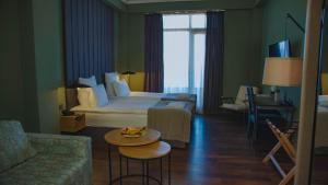 a hotel room with a bed and a couch and a table at Boulevardside in Batumi