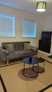 ein Wohnzimmer mit einem Sofa und einem Tisch in der Unterkunft Alexander Apartments Heaton in Heaton