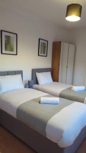 2 Betten nebeneinander in einem Zimmer in der Unterkunft Alexander Apartments Heaton in Heaton