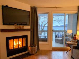 a living room with a fireplace and a television at OMagogcondo com A in Magog-Orford
