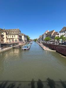 une rivière avec des bateaux dans une ville avec des bâtiments dans l'établissement Appart & Studio Hyper Centre de Strasbourg - Proche Cathédrale & Petite France, à Strasbourg