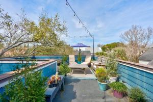 eine Terrasse mit einem Stuhl und einem Sonnenschirm auf dem Dach in der Unterkunft Elegant Sunlit Home with Private Rooftop Oasis in Charleston