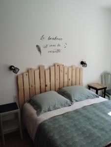 a bedroom with a bed with a wooden headboard at Superbe maison de famille proche du circuit des 24h in Écommoy