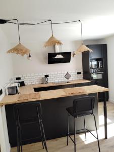 a kitchen with a counter and two chairs at Maison de famille in Écommoy +7 photos