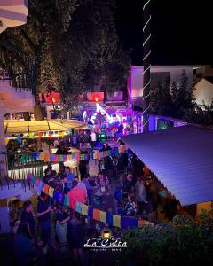 een menigte mensen die 's nachts op een feestje zitten bij La Culta hostal & centro cultural in Sucre