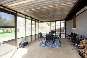 um alpendre com cadeiras, mesas e janelas em Pet-friendly 3br 2ba with huge, fenced yard! em Amarillo