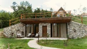 ein Steinhaus mit einer Terrasse darüber in der Unterkunft Eko Zaseok Brana 
