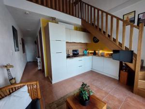 eine Küche mit weißen Schränken und einer Wendeltreppe in der Unterkunft Location de vacances Bord'O in San-Nicolao