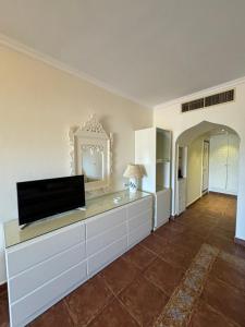a living room with a flat screen tv on a dresser at Sharm Prestige Room 52 - Luxury sea view at coral bay in Sharm El Sheikh