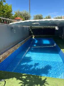 una piscina de agua azul en un patio en Dar el kebira, en Meknès