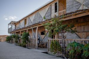 a wooden building with a boardwalk in front of it at Watu Kite House in Mayapo