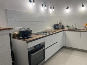 a kitchen with white cabinets and a stove top oven at Il Nido in Teulada