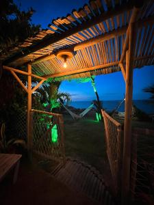 a pergola with a view of the ocean at night at Raio de Sol Residence in Canoa Quebrada