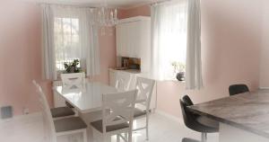 a white kitchen with a white table and chairs at Dom Jeziorna Perla in Ośno Lubuskie