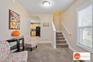 a living room with a staircase and a table and chairs at Downtown Holland Charmer in Holland