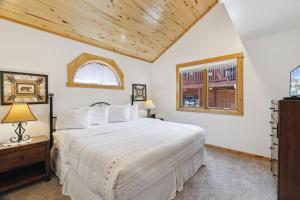 a bedroom with a large white bed and a window at Bugle Pointe A06 by Estes Park Condos in Estes Park +14 photos