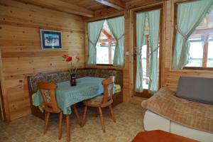 a dining room with a table and chairs and a couch at Drina Na Vodi in Bajina Bašta