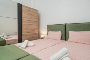 a bedroom with a pink bed with a green headboard at NEON 2BR Luxurious Central Apt Heraklion in Heraklio Town