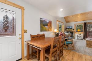 a dining room and living room with a wooden table and chairs at Bugle Pointe A12 by Estes Park Condos in Estes Park