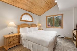 a bedroom with a large white bed and a window at Bugle Pointe A12 by Estes Park Condos in Estes Park