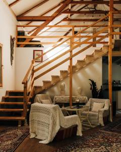 a living room with stairs and chairs and a table at Home of arts and creation, Erdei alkoto studio in Kismaros