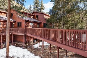 a wooden house with a bridge in the woods at Bugle Pointe A14 by Estes Park Condos in Estes Park