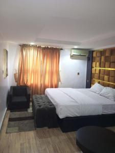 a hotel room with a bed and a chair at Dino international Hotel in Ibadan