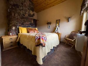 1 dormitorio con cama y pared de piedra en Zion Villa True North, en Springdale