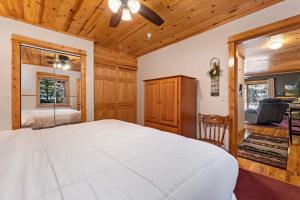 a bedroom with a white bed and a ceiling fan at Bugle Pointe B10 by Estes Park Condos in Estes Park