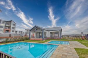 a swimming pool in front of a house at Nala Realty at The Aura in Sandton