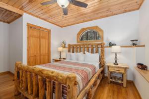 a bedroom with a wooden bed and a ceiling fan at Bugle Pointe B14 by Estes Park Condos in Estes Park +10 photos