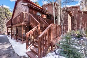 una casa con una escalera de madera en la nieve en Bugle Pointe B15 by Estes Park Condos, en Estes Park