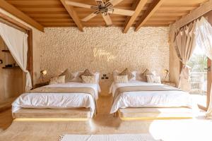a bedroom with three beds with white sheets at AWA Holbox Hotel Boutique - Beach Front in Holbox Island