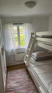 Malghults Gård في Kristdala: غرفة نوم مع سرير بطابقين ونافذة