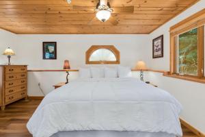 a bedroom with a white bed and a wooden ceiling at Bugle Pointe B20 by Estes Park Condos in Estes Park