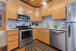 a kitchen with wooden cabinets and stainless steel appliances at Bugle Pointe B20 by Estes Park Condos in Estes Park