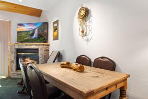 une salle à manger avec une table en bois et une cheminée dans l'établissement Creekside Condos D by Estes Park Condos, à Estes Park