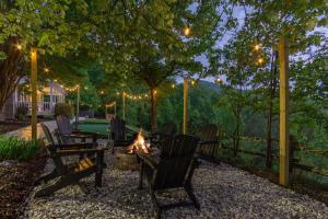 a fire pit in a backyard with chairs and a table at Massive Asheville Compound A Memorable Experience in Weaverville