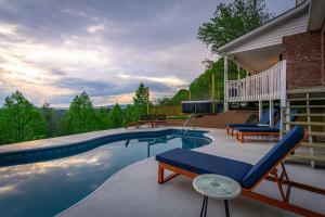 a swimming pool with two lounge chairs next to a house at Massive Asheville Compound A Memorable Experience in Weaverville