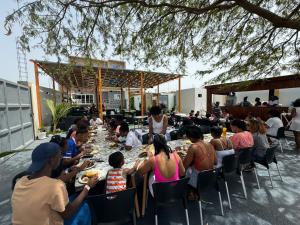 un gruppo di persone sedute a un lungo tavolo di Pereira Lounge Bar a Praia