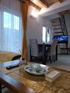 a living room with a table and a bed and a piano at Apartmani Lena in Pluzine