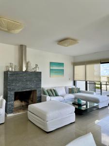a living room with a couch and a fireplace at Amplio duplex al mar en manantiales in Punta del Este