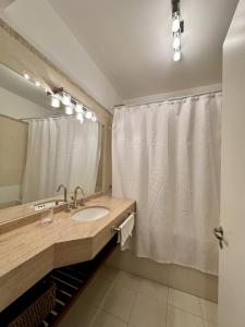 a bathroom with a sink and a shower curtain at Amplio duplex al mar en manantiales in Punta del Este