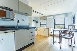 a kitchen with white cabinets and a table with chairs at Apartamento no Comfot hotel in Brasilia