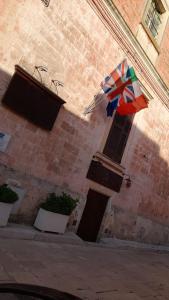 un ombrello è appeso sul lato di un edificio di Palazzo Mellacqua ad Andrano